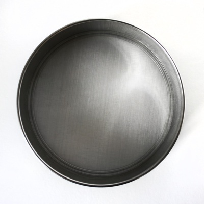 Tabuleiro redondo de metal cinzento sobre fundo branco