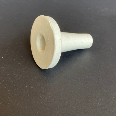 Peça cônica de cerâmica branca sobre superfície escura