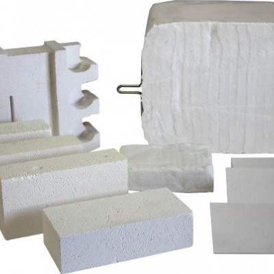 Peças de material isolante térmico branco com várias formas e texturas sobre fundo branco.