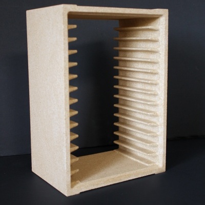 Estrutura retangular bege com ranhuras internas colocada em fundo preto