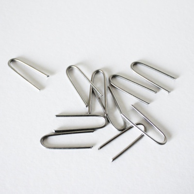Grampos metálicos prateados em superfície branca