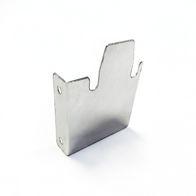 Peça metálica cinza prateada com recortes e furos sobre fundo branco