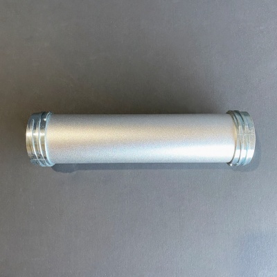 Objeto cilíndrico prateado com extremidades metálicas sobre superfície cinza