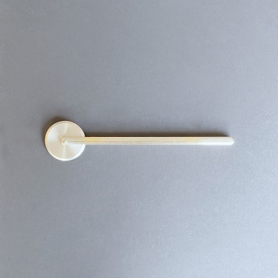 Régua branca de plástico com suporte circular branco sobre fundo cinzento.