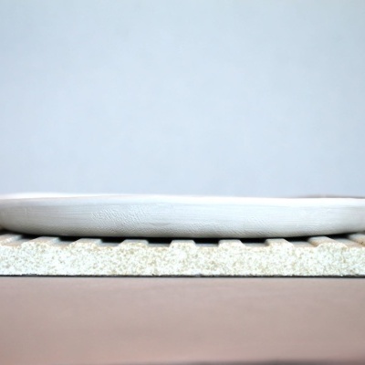 Prato branco de cerâmica oval em base rugosa cinza