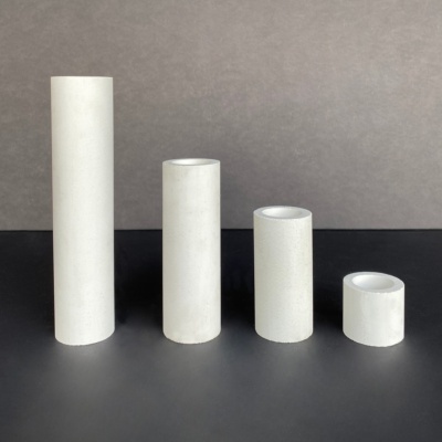 Quatro velas brancas de várias alturas sobre superfície preta