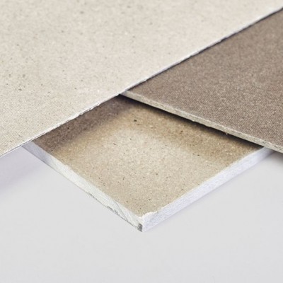 Três placas de gesso cartonado empilhadas em tons bege e cinzento.