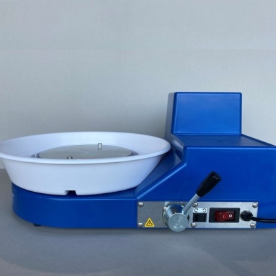 Máquina de olaria azul com prato branco e painel com alavanca e visor digital