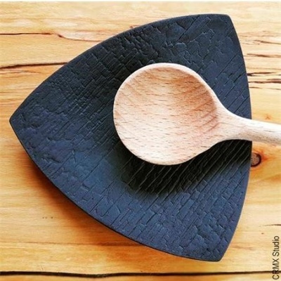 Prato triangular preto texturizado com colher de madeira clara