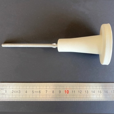 Ferramenta com punho branco e haste metálica ao lado de uma régua