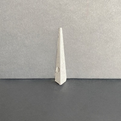 Objeto triangular pontiagudo cinza claro em superfície escura com fundo cinza