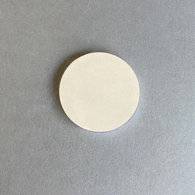 Disco redondo branco sobre superfície cinza