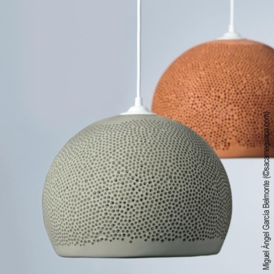 Dois candeeiros pendentes esféricos cinzento e castanho com padrão de furos, suspensos por cabos brancos