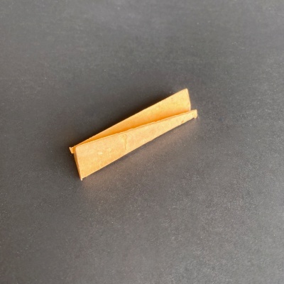 Dois triângulos de papel castanho dobrado sobre fundo preto