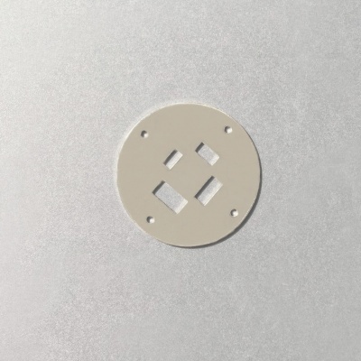 Placa redonda branca com furos e cortes quadrangulares