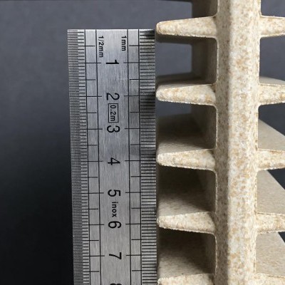 Objeto branco rugoso com formato espiculado ao lado de régua metálica com medidas em centímetros