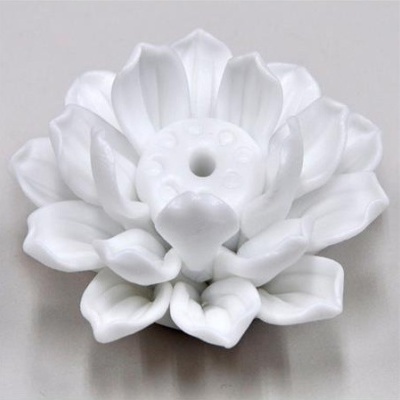 Objeto decorativo branco em forma de flor com pétalas curvas e centro redondo.