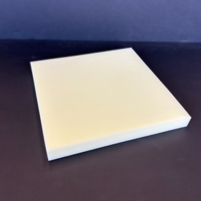 Bloco quadrado de espuma branca sobre superfície escura e fundo azul