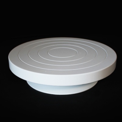 Prato giratório branco com círculos concêntricos em relevo sobre fundo preto