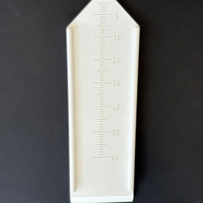 Medidor branco com escala de 0 a 60 sobre fundo preto