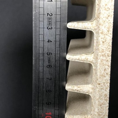 Produto cerâmico com espaçadores e régua ao lado em fundo preto.