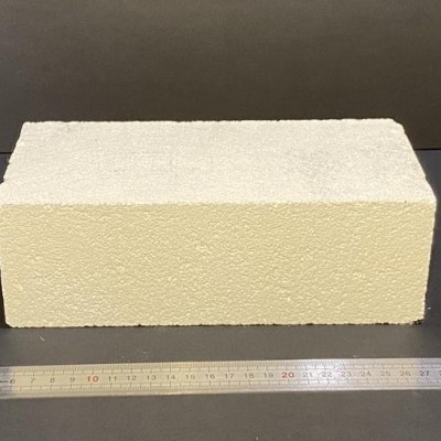 Bloco rectangular de espuma bege com régua metálica em fundo cinzento
