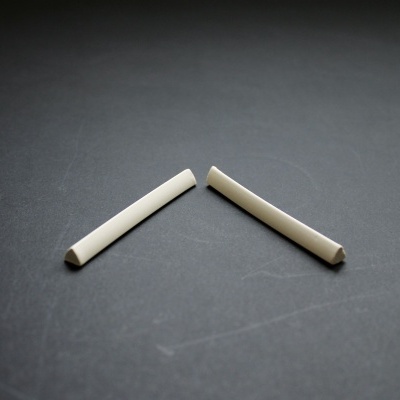 Dois pedaços de giz branco sobre superfície preta fosca