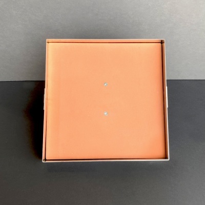 Caixa quadrada laranja com dois elementos brilhantes no centro