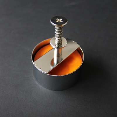 Forma redonda de metal para moldar alimentos com parafuso no topo e interior laranja