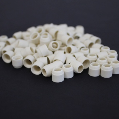 Pequenos acessórios cilíndricos brancos sobre superfície preta