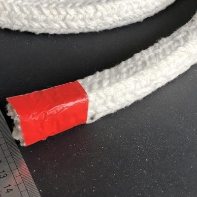 Corda branca trançada com fita vermelha e régua metálica ao lado