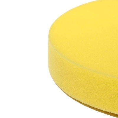 Esponja redonda amarela de espuma sobre fundo branco