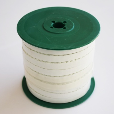 Bobina de cordão branco com costura verde em carretel verde