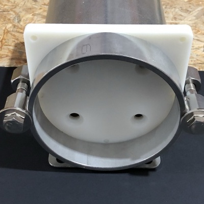 Produto metálico cilíndrico prateado com base branca e molas laterais