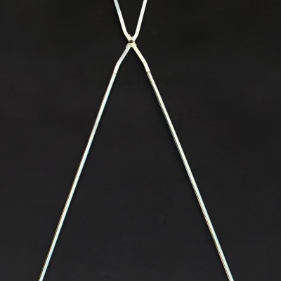 Espeto metálico para grelhar com duas hastes longas e dobradiça no topo em fundo preto