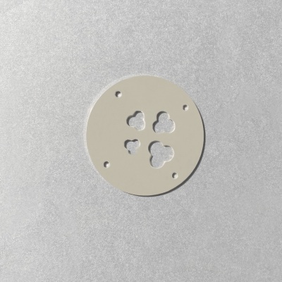 Disco redondo branco com furos em forma de nuvem sobre fundo cinza