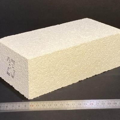 Bloco branco esponjoso retangular ao lado de uma régua metálica