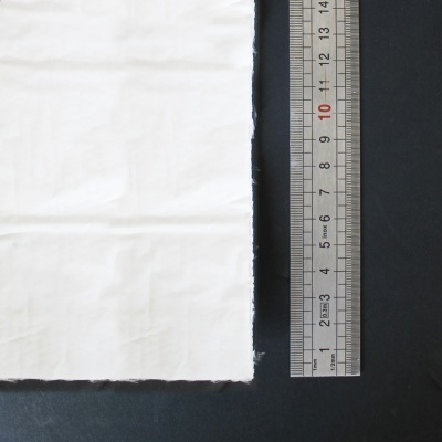 tecido branco serrilhado ao lado de régua metálica até 15 cm