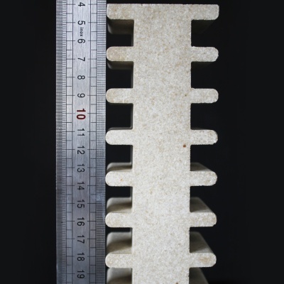 Peça bege com recortes e régua metálica ao lado