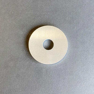 Roda circular branca com orifício central sobre fundo cinzento