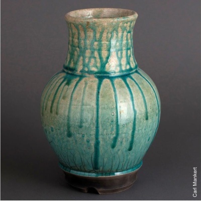 Jarro de cerâmica azul-turquesa com gotas verticais e base preta