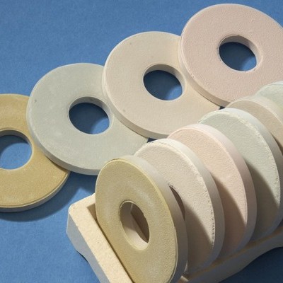 Anéis circulares pastéis em suporte branco sobre fundo azul