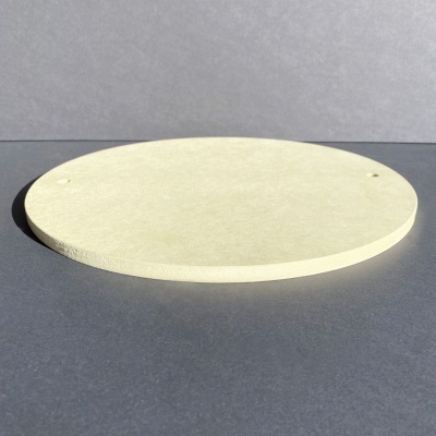 Placa circular bege com textura rugosa sobre fundo cinzento