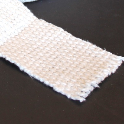 Faixa de tecido branco com textura de malha grosso sobre fundo preto