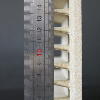 Régua metálica com peça de cerâmica ou concreto texturizada em fundo preto