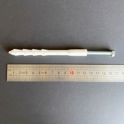 Parafuso e bucha de fixação com régua num fundo cinza