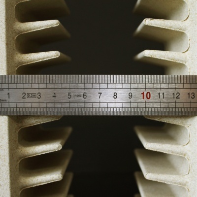 Régua metálica sobre peça industrial cinza-claro com ranhuras