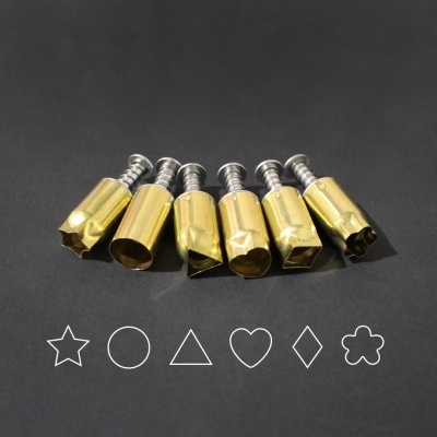 Seis moldes metálicos dourados com diferentes formas de corte