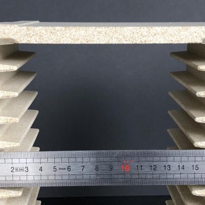 Bloco isolante bege claro com ranhuras e régua metálica em centímetros à frente