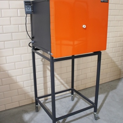 Forno industrial laranja e preto sobre estrutura metálica com rodas